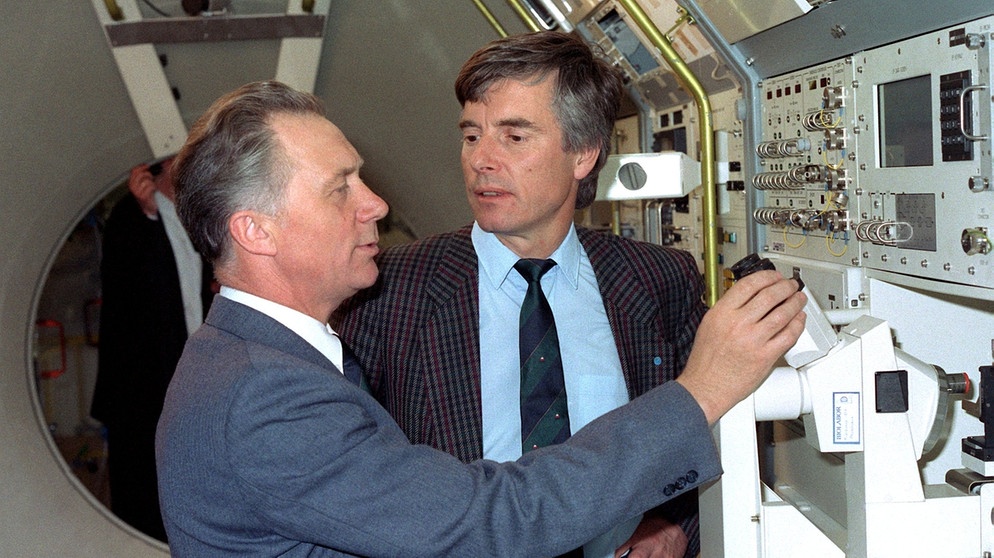 Der DDR-Kosmonaut Sigmund Jähn fachsimpelt im April 1990 mit seinem westdeutschen Kollegen, dem Astronauten Ulf Merbold. | Bild: picture-alliance/dpa
