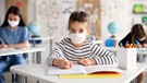 Ein Schulkind mit Maske im Unterricht. | Bild: stock.adobe.com/Halfpoint