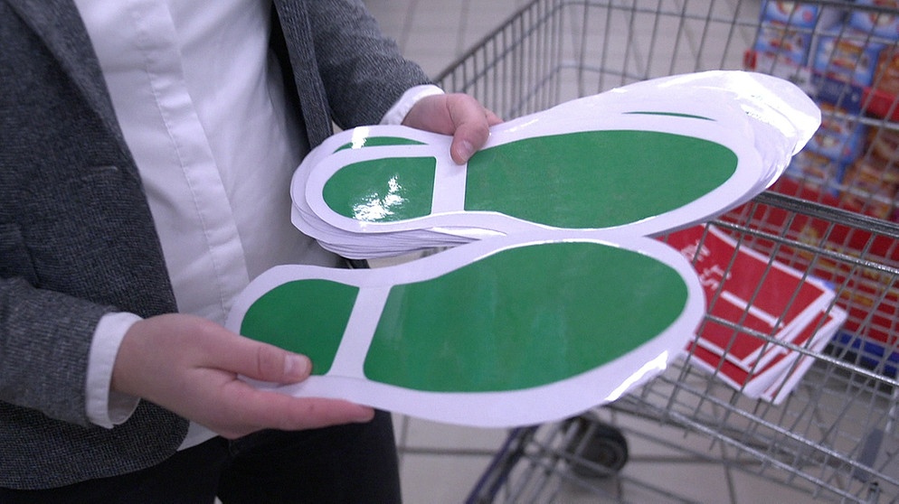 Mit Fußabdrücken auf den Boden sollen Abstände beim Einkaufen eingehalten werden.  | Bild: BR/Gut zu wissen