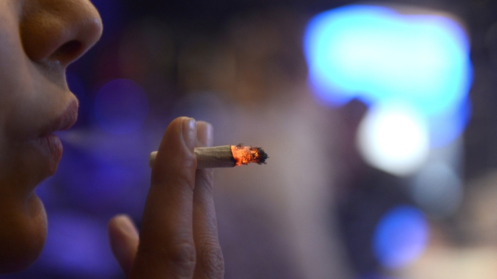 Frau zieht an einer brennenden Zigarette. | Bild: dpa-Bildfunk