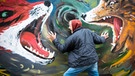 Mann steht vor einer Graffiti-Wand. Verzweiflung, Sorgen und Ängste nehmen die Lebensfreunde. Wird der Leidensdruck zu groß, kann eine Psychotherapie helfen.  | Bild: picture-alliance/dpa