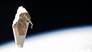 Ein Schutzschild vor Weltraumschrott von der ISS schwebt im Weltall. Der Schild soll den Alpha Magnetic Spectrometer vor Weltraumschrott schützen und wurde bei Reparaturarbeiten im Jahr 2019 von den Raumfahrern Andrew Morgan and Luca Parmitano entfernt. | Bild: NASA