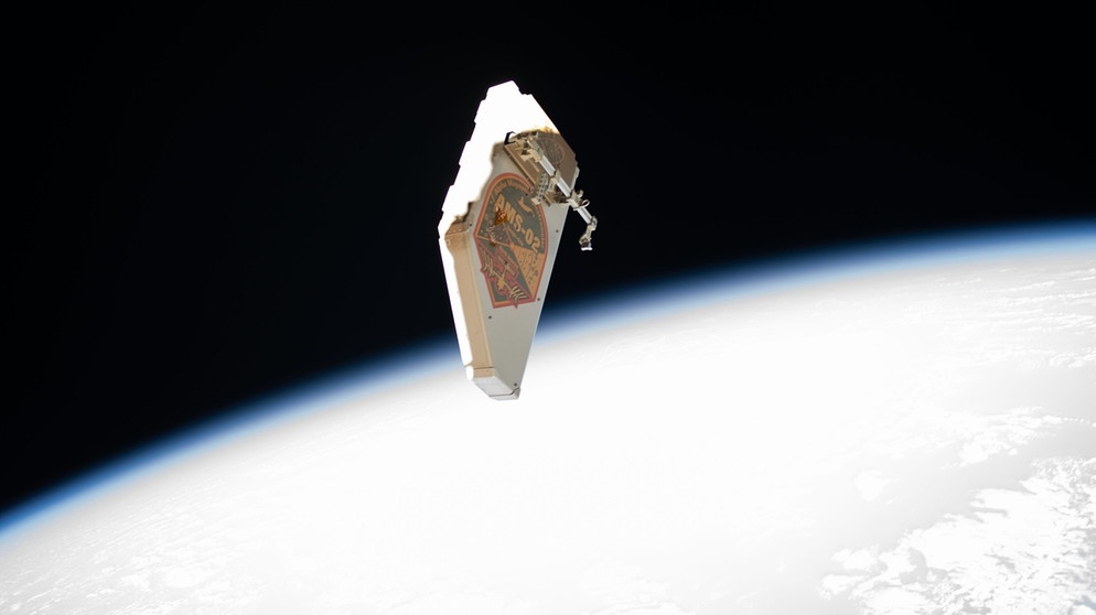 Ein Schutzschild vor Weltraumschrott von der ISS schwebt im Weltall. Der Schild soll den Alpha Magnetic Spectrometer vor Weltraumschrott schützen und wurde bei Reparaturarbeiten im Jahr 2019 von den Raumfahrern Andrew Morgan and Luca Parmitano entfernt. | Bild: NASA