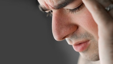 Junger Mann mit Schmerzen fasst sich an den Kopf | Bild: colourbox.com