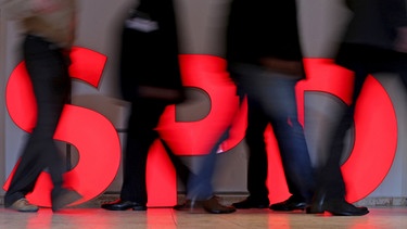 Menschen laufen an einem roten SPD-Schriftzug vorbei, der am Boden steht | Bild: dpa-Bildfunk/Jan Woitas