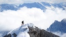 Ein Bergsteiger geht auf dem Jubiläumsgrat unweit des Gipfels der Zugspitze durch den Schnee | Bild: picture-alliance/dpa
