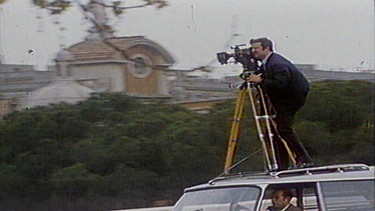 Kameramann filmt auf einem fahrenden Auto. | Bild: BR / Studio Rom