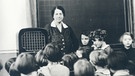 Schüler mit Lehrerin vor Volksempfänger | Bild: BR/Historisches Archiv