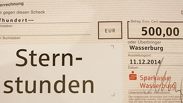 Der Spendenscheck der Sparkasse Wasserburg über 500 Euro | Bild: BR/Andreas Dirscherl