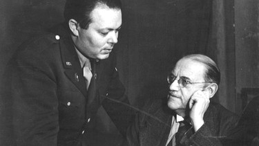 Oberbürgermeister Karl Scharnagl (rechts) vor seiner Rundfunkansprache mit dem
"Production Manager" Norbert Grünfeld, 1946.
| Bild: BR, Historisches Archiv / Ruth Schramm