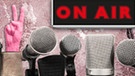 Viele Mikrofone vor einem erleuchteten "On-Air"-Schild und einer 24-Stunden-Uhr mit Kopfhörer | Bild: BR/Tanja Begovic