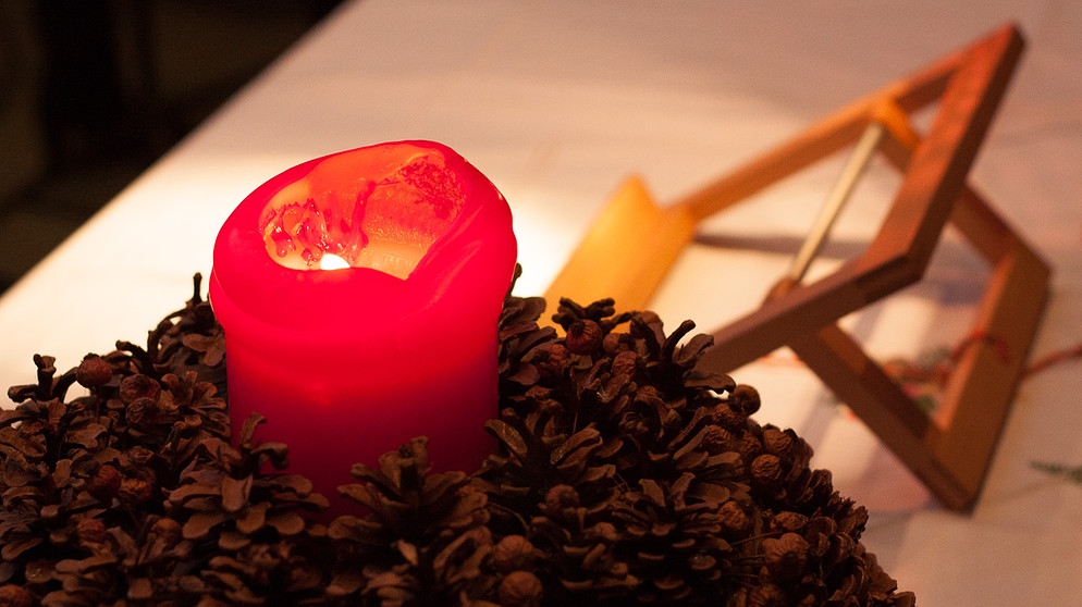 Eine Kerze brennt am Adventskranz | Bild: BR/Andreas Dirscherl