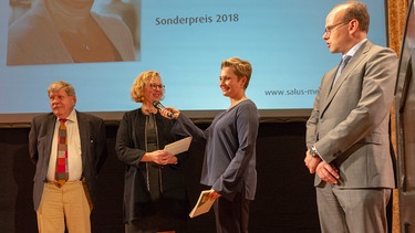 Preisverleihung mit Laudator und Geschäftsführer und Moderatorin Janine Steeger. | Bild: Salus/Katharina Schildhauer