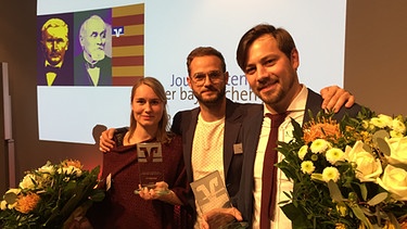 v. l. Julia Häglsperger (Autorin), Rainer Maria Jilg (Presenter), Robert Grantner (Autor) | Bild: Genossenschaftsverband Bayern / Thomas Straub