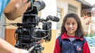 Mädchen vor einer Fernsehkamera - Kinderfernsehmacher treffen sich zur PRIX JEUNESSE Konferenz 2021 | Bild: WADADA/Free Press Unlimited