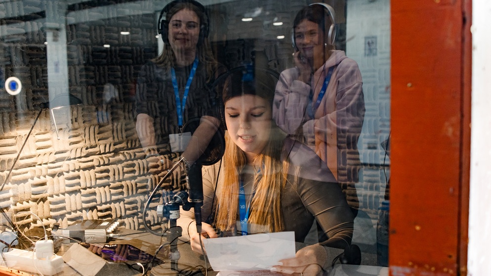 Schülerinnen stehen an der Radiostation und können sich als Radiosprecherin ausprobieren. | Bild: BR/Vera Johannsen