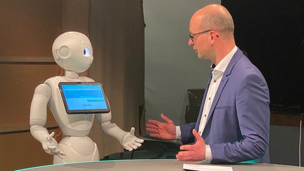 Moderator Christian Nitsche spricht mit Roboter Pepper. | Bild: BR