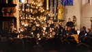 Blick aus einer hinteren Reihe über das Publikum hinweg auf den Christbaum und den Singkreis Gempfing in der Pfarrkirche St. Vitus | Bild: Erich Hofgärtner