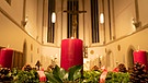 Der Adventskranz im Münster Heidenheim. Im Hintergrund das Christuskreuz. | Bild: BR/Christopher Mann + Andreas Dirscherl