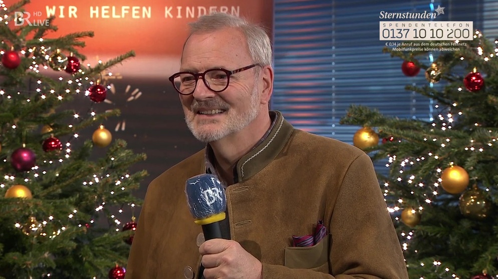 Martin Fogt mit Mikrofon vor Christbäumen im Sternstunden-Tag Fernsehstudio | Bild: BR/Andreas Dirscherl