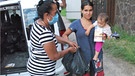 Frau mit Kleinkind erhält von anderer Frau Tüte mit Spenden. | Bild: nehemia team e.V.