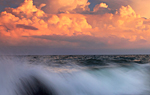 Sonnenbeschienene Wolken türmen sich über dem Meer auf. © Colourbox