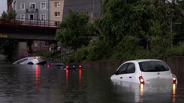 Autos in einer überfluteten Unterführung. | Bild: BR