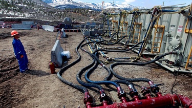 Fracking: Ein Arbeiter hilft bei der Überwachung des Drucks und der Temperatur der Wasserpumpe außerhalb von Rifle im Westen Colorados. | Bild: picture alliance / AP Photo | Brennan Linsley